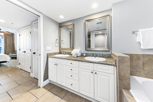 a bathroom with two sinks and two mirrors at 5 Portofino 1106 at Pensacola Beach in Pensacola Beach