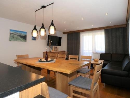 une salle à manger et un salon avec une grande table en bois dans l'établissement Apartment for allergy sufferers near the waterfall, à Krimml