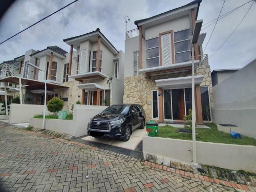 巴圖的住宿－Villa Bahari Batu，停在房子前面的一辆黑色汽车