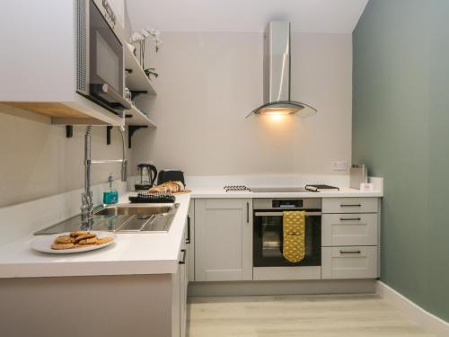a small kitchen with a sink and a stove at Windermere in Kendal