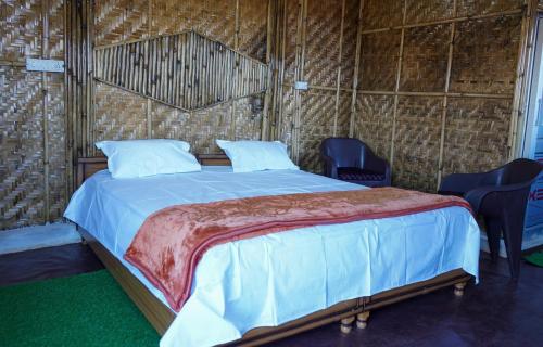 a bed in a room with some chairs and a bed sidx sidx sidx at Secret Staycation Nature Cottages in Kandāghāt