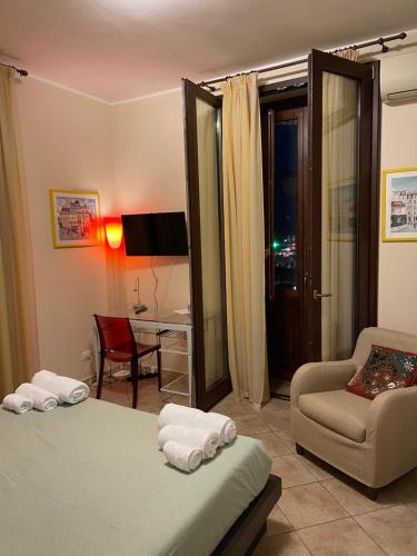 a bedroom with a bed and a chair and a desk at Catania Duomo Shine in Catania