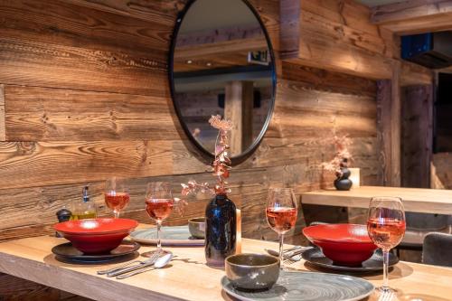 a table with wine glasses and a mirror at No 8 Bed & Bar in Verbier