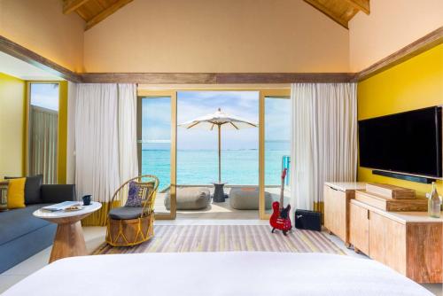 a bedroom with a bed and a view of the ocean at Hard Rock Hotel Maldives in South Male Atoll
