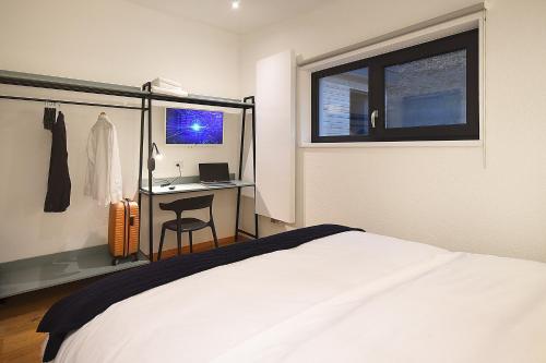 ein Schlafzimmer mit Bett, Schreibtisch und Fenster in der Unterkunft Kub House Village in Slănic-Moldova