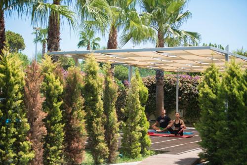 two men sitting under a pavilion in a garden at TUI Blue Barut Andız - All Inclusive - Adults Only in Side