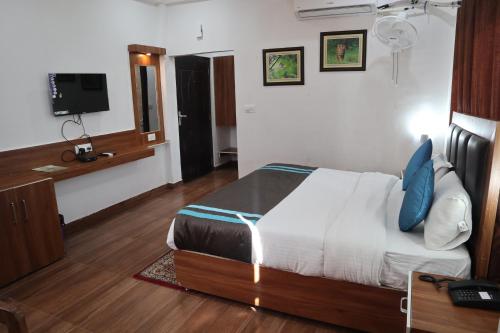 a hotel room with a bed and a television at Seven Corbett in Rāmnagar