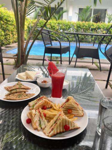 a table with two plates of food and a drink at La Vera Boutique Hotel, Mandrem in Mandrem