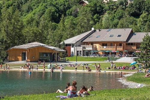 a group of people on the beach near a lake at Studio vue montagne proche des pistes in Orcières