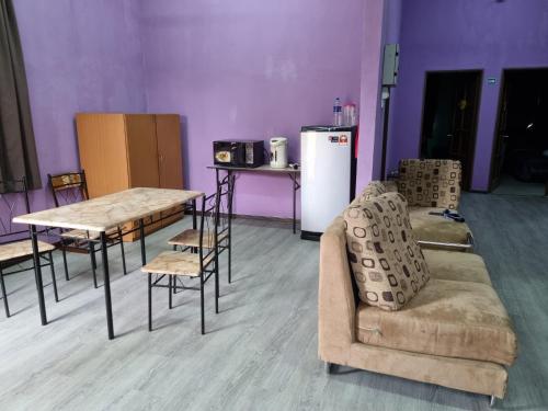 um quarto com uma mesa e cadeiras e um frigorífico em E.R. BUDGET INN em Kota Bharu