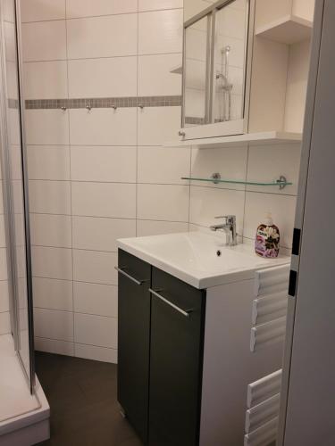 a bathroom with a sink and a mirror at Haus Sachsensteinblick Ferienwohnung Sonnenschein in Bad Sachsa