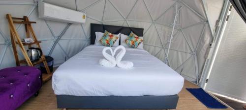 ein Schlafzimmer mit einem Bett mit zwei weißen Kaninchen darauf in der Unterkunft เขาเจ้าขา2 in Khao Kho