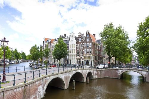 a bridge over a river in a city with buildings at Hotel Fine Harmony in Amsterdam