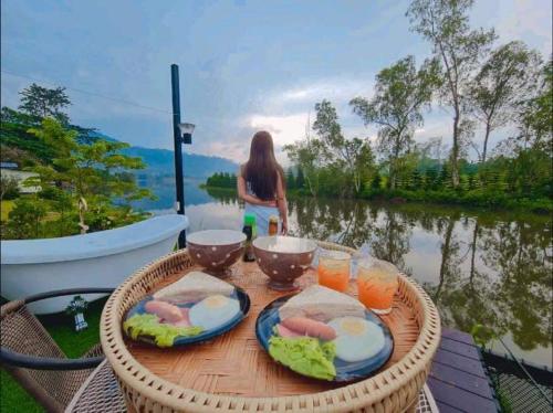 a table with food and drinks on a table near a body of water at เขาเจ้าขา2 in Khao Kho