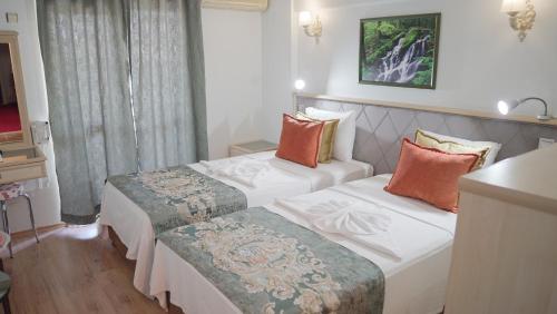 a hotel room with two beds in a room at Panormos Hotel in Didim