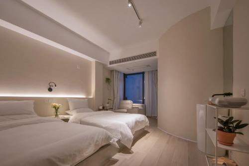 a hotel room with two beds and a bathroom at IM Waiting Hotel in Yangshuo