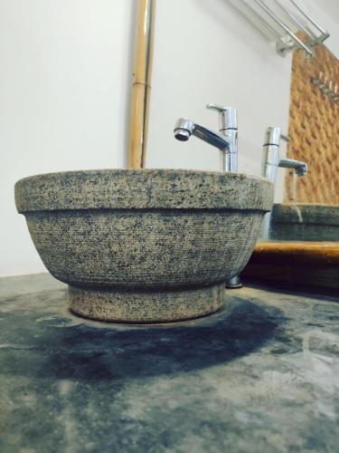 a stone sink with two faucets in a room at Samyama Retreat in Cola