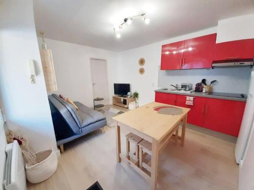 kuchnia z czerwonymi szafkami i stołem w pokoju w obiekcie LE BILBAO, T2, centre-parking gratuit-terrasse w mieście Tarbes