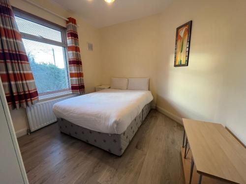 a bedroom with a bed and a table and a window at The D3 Self Catering in Dublin