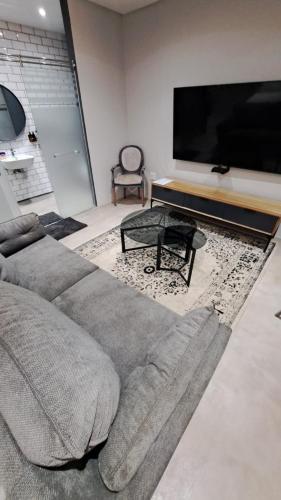 a living room with a couch and a flat screen tv at The Doors Inn in Mokopane
