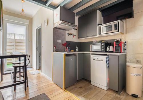 ボルドーにあるDuplex-terrasse-parking-climatisationのキッチン(ステンレス製の電化製品、テーブル付)