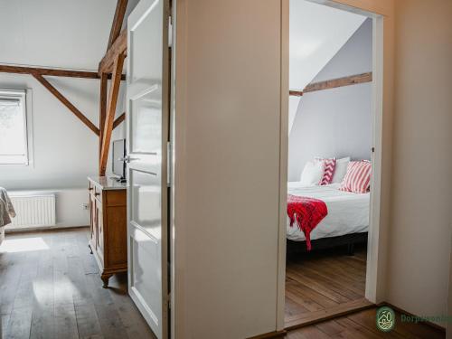 1 dormitorio con cama y espejo grande en Vibrant Farmhouse near Forest in Heeze-Leende, en Leende