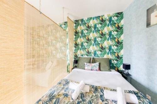 Schlafzimmer mit einem Bett mit Blumentapete in der Unterkunft Superbe studio apartment à 2MN de Paris in Gentilly