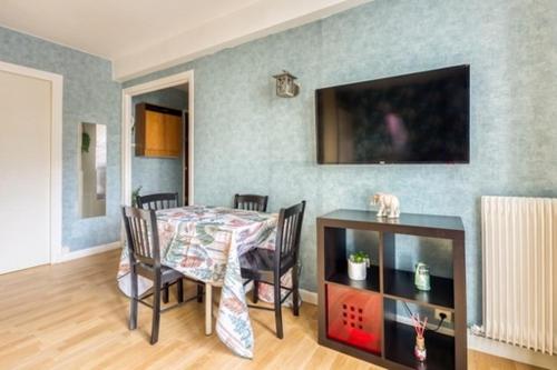 a dining room with a table and chairs and a table at Superbe studio apartment à 2MN de Paris in Gentilly