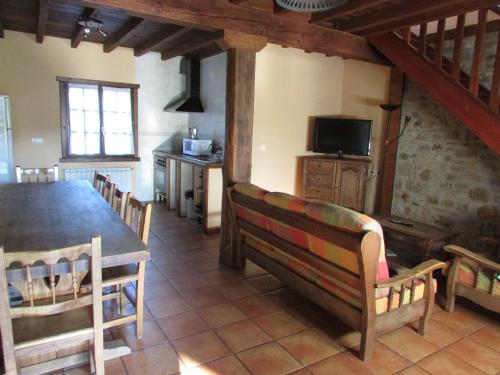 a dining room with a table and chairs and a television at Kerizara Baserria in Ochandiano