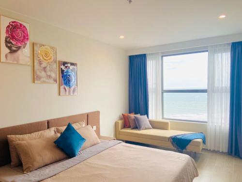 a bedroom with a bed and a window with the ocean at Căn hộ The Sóng An Gia - Vũng Tàu Apartment in Vung Tau