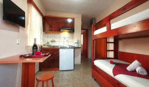 a bedroom with a bunk bed and a kitchen at Apartmenthotel Sithon in Sarti