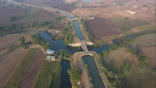 eine Luftansicht einer Brücke über einen Fluss in der Unterkunft Tarangini Farmstay in Maheshwar