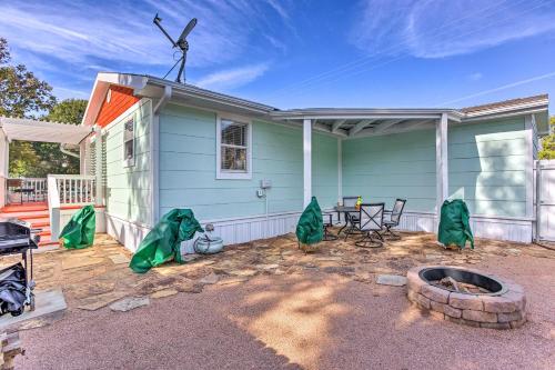 a green house with a patio with a table at Walk to Cedar Creek Reservoir Home with Fire Pit! in Tool