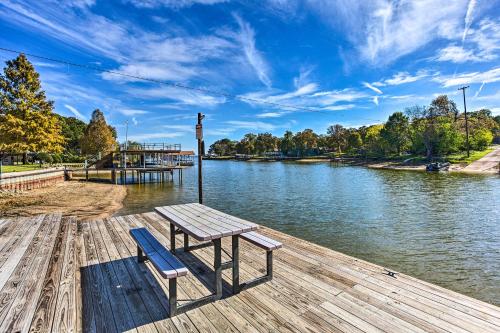 a picnic table and a bench on a dock next to a river at Walk to Cedar Creek Reservoir Home with Fire Pit! in Tool