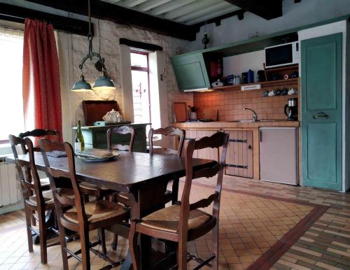 cocina con mesa de madera y sillas en Moulin des Vernes, en Ouroux