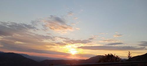 a sunset in the mountains with the sun in the sky at Arcadianis lakeview villa at Psari Arkadias in Psárion
