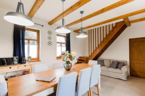 cocina y comedor con mesa de madera y sillas en Elizabeth Cottage Benczúrfalva, en Szécsény