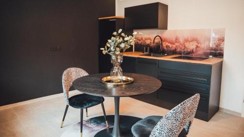 a dining room table with chairs and a vase with flowers at Love Cottage mit Whirlpool in Hagen