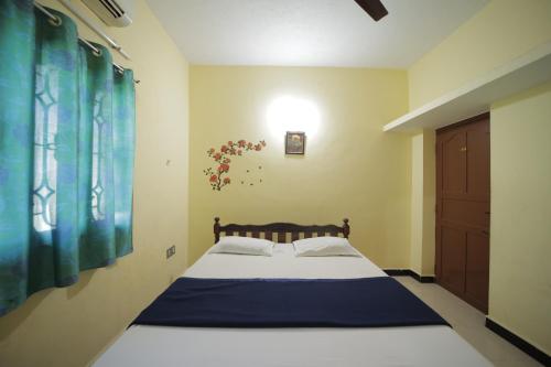 本地治里的住宿－Karthik residence，一间卧室配有一张带蓝色毯子的大床