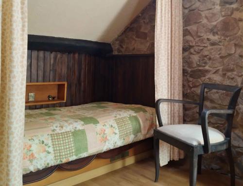 1 dormitorio con 1 cama y 1 silla en Moulin des Vernes, en Ouroux