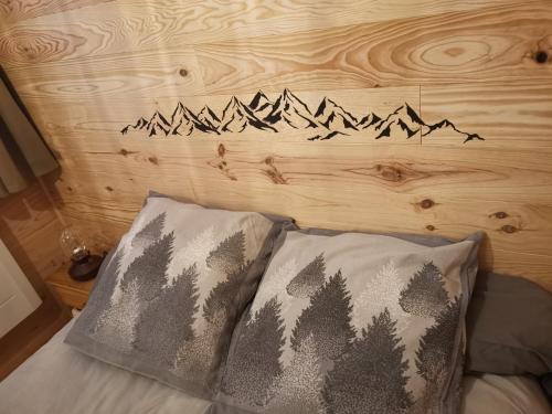 ein Bett mit einem Kopfteil mit Bergen darauf in der Unterkunft Ha Py Chalet in Campan