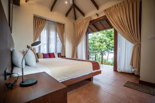 a bedroom with a bed and a large window at Island View Beachfront Resort in Anda