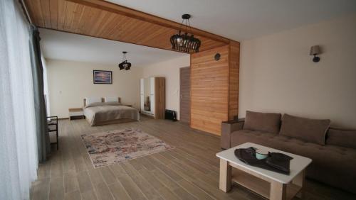 uma sala de estar com um sofá e uma cama em Boutique Villas Murgavets Pamporovo em Pamporovo