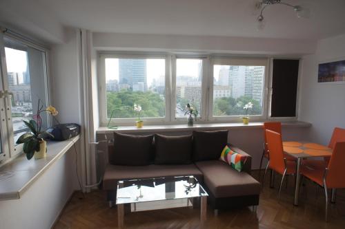 sala de estar con sofá, mesa y ventanas en bonApartments, en Varsovia