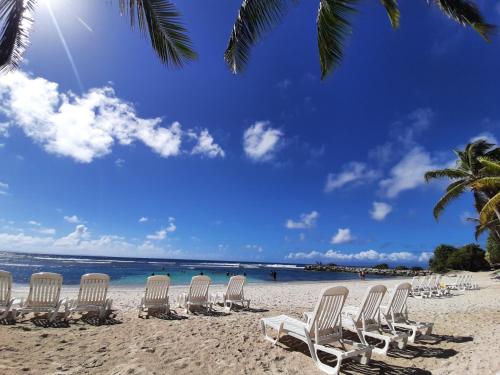 un grupo de sillas sentadas en una playa en STUDIO CARAMBOLE VUE MER - Piscines - Plages - Village vacances Sainte Anne Guadeloupe en Sainte-Anne