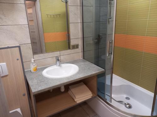 a bathroom with a sink and a shower at Pokoje Gościnne Jaga in Kielce