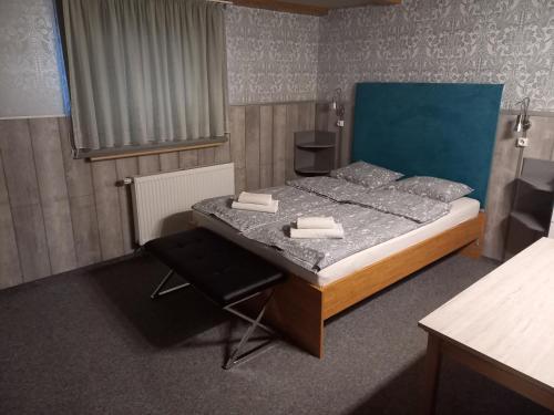 a small bedroom with a bed and a chair at Pokoje Gościnne Jaga in Kielce
