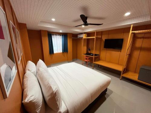 a bedroom with a large white bed and a flat screen tv at Sari Boutique hotel in Patong Beach