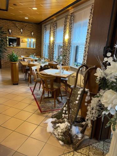 a restaurant with tables and chairs and windows at Gasthaus Hubertus in Reuth