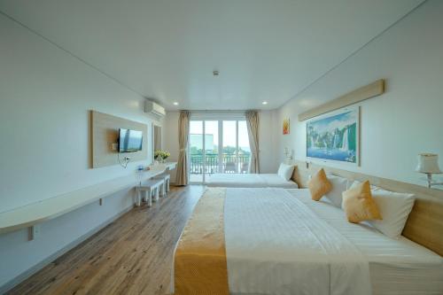 フーコックにあるSummer Dream Hotelの大きなベッドとテレビがあるホテルの部屋